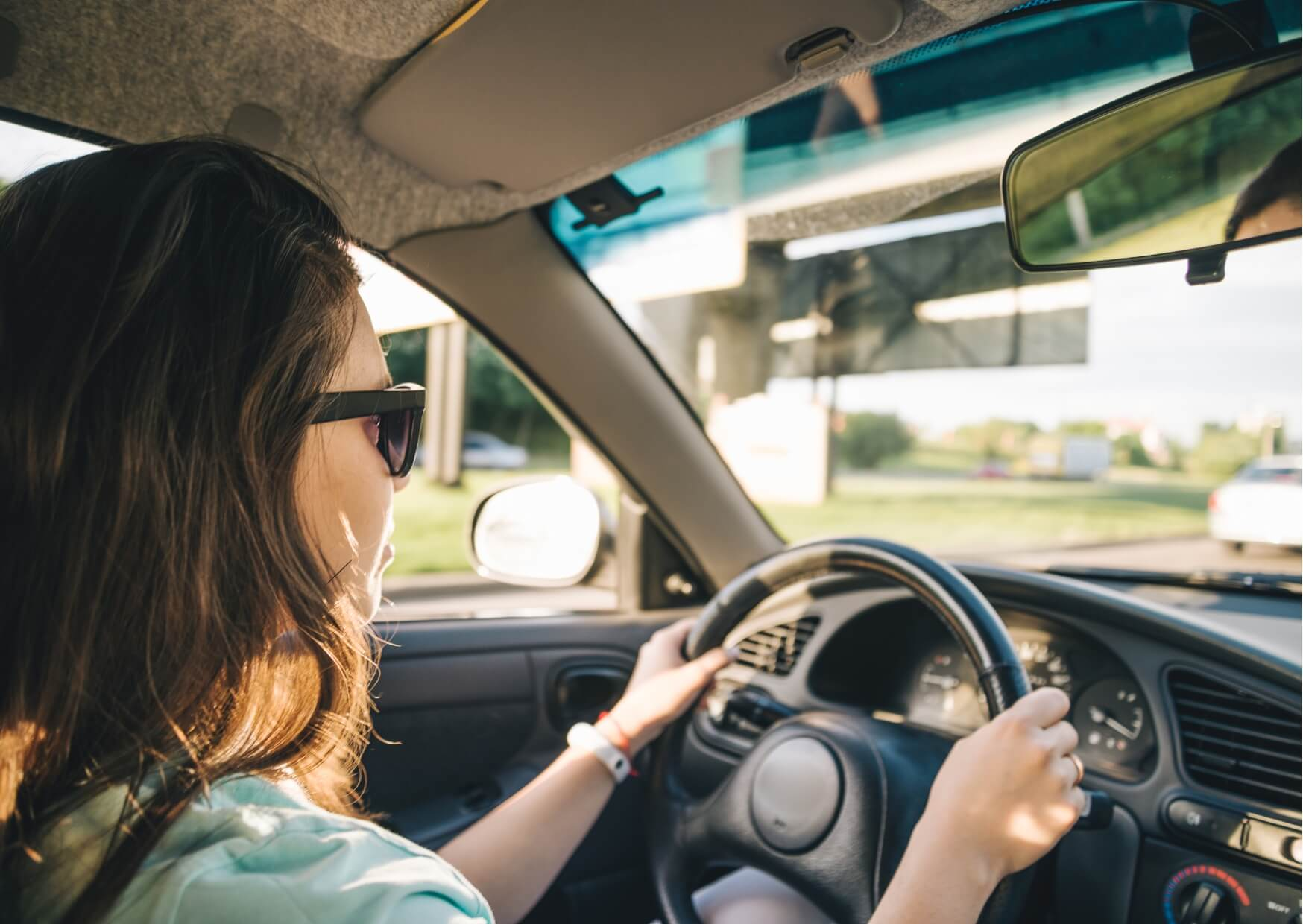 Woman driving a car after a dental appointment, illustrating considerations about whether you can drive after a root canal procedure.
