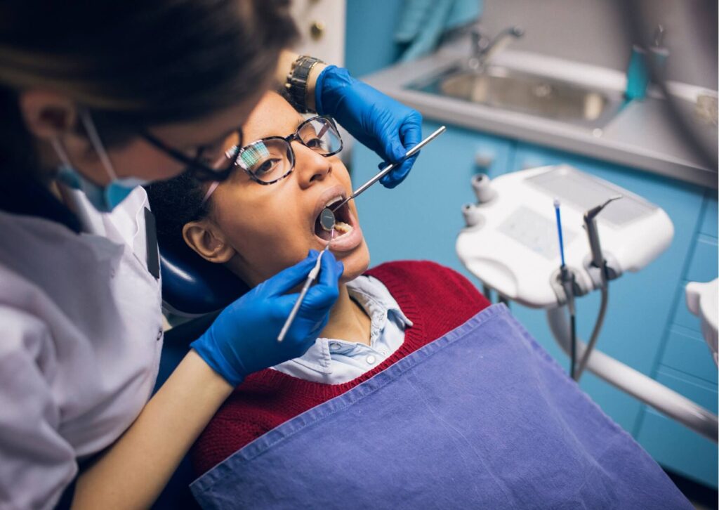 Dentist examining a patient’s gums during a dental checkup to detect early signs of gingivitis and prevent gum disease progression.