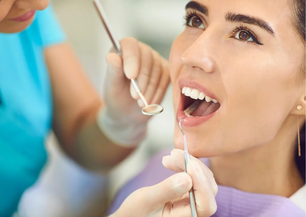 Dentist examining a patient’s teeth for cavities during a routine dental checkup.