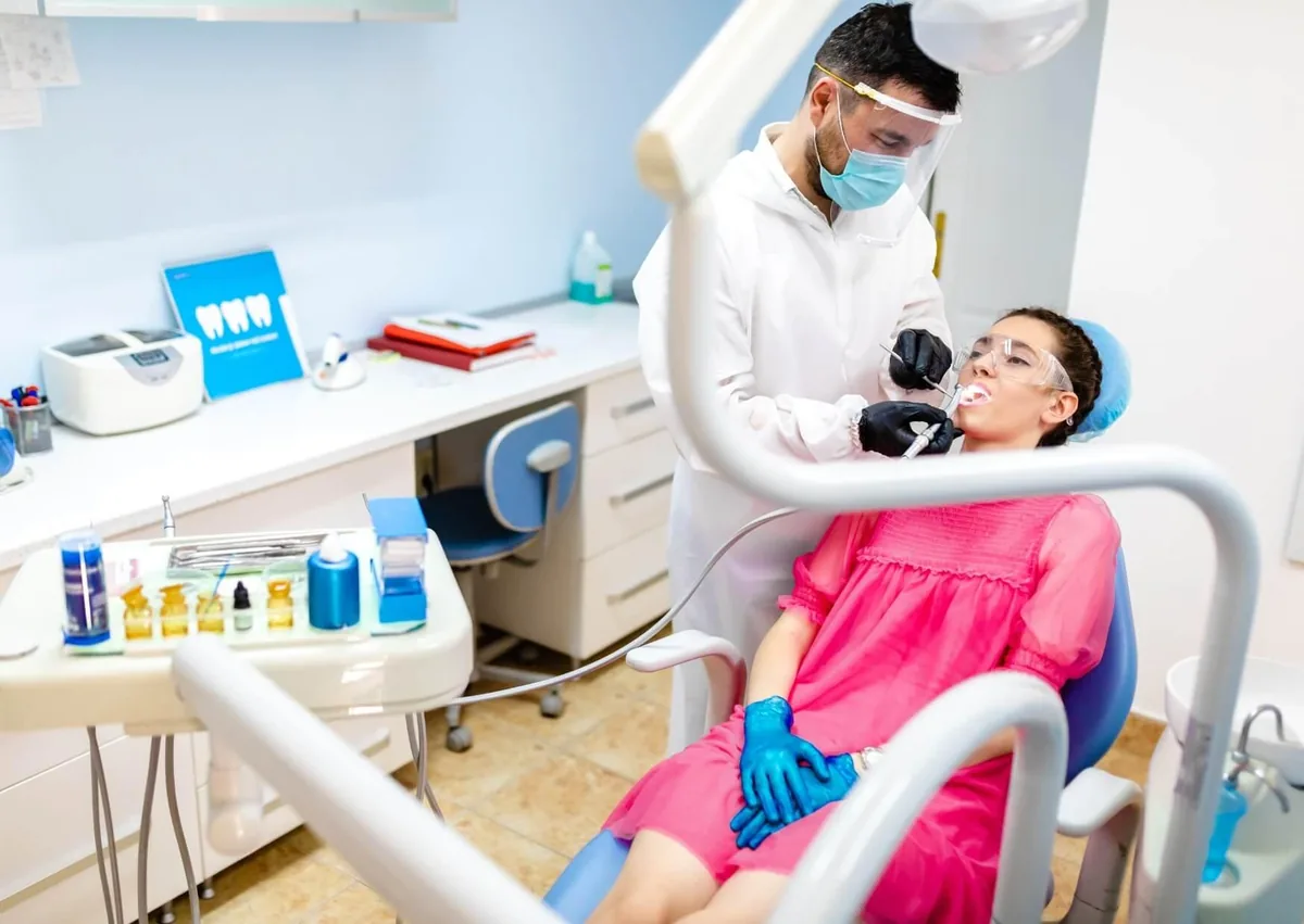 Dentist performing a gum contouring procedure on a patient to reshape the gumline.