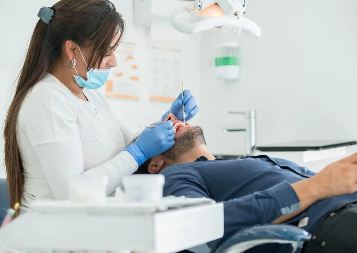 Dentist examining a patient for oral health problems related to persistent dry mouth.
