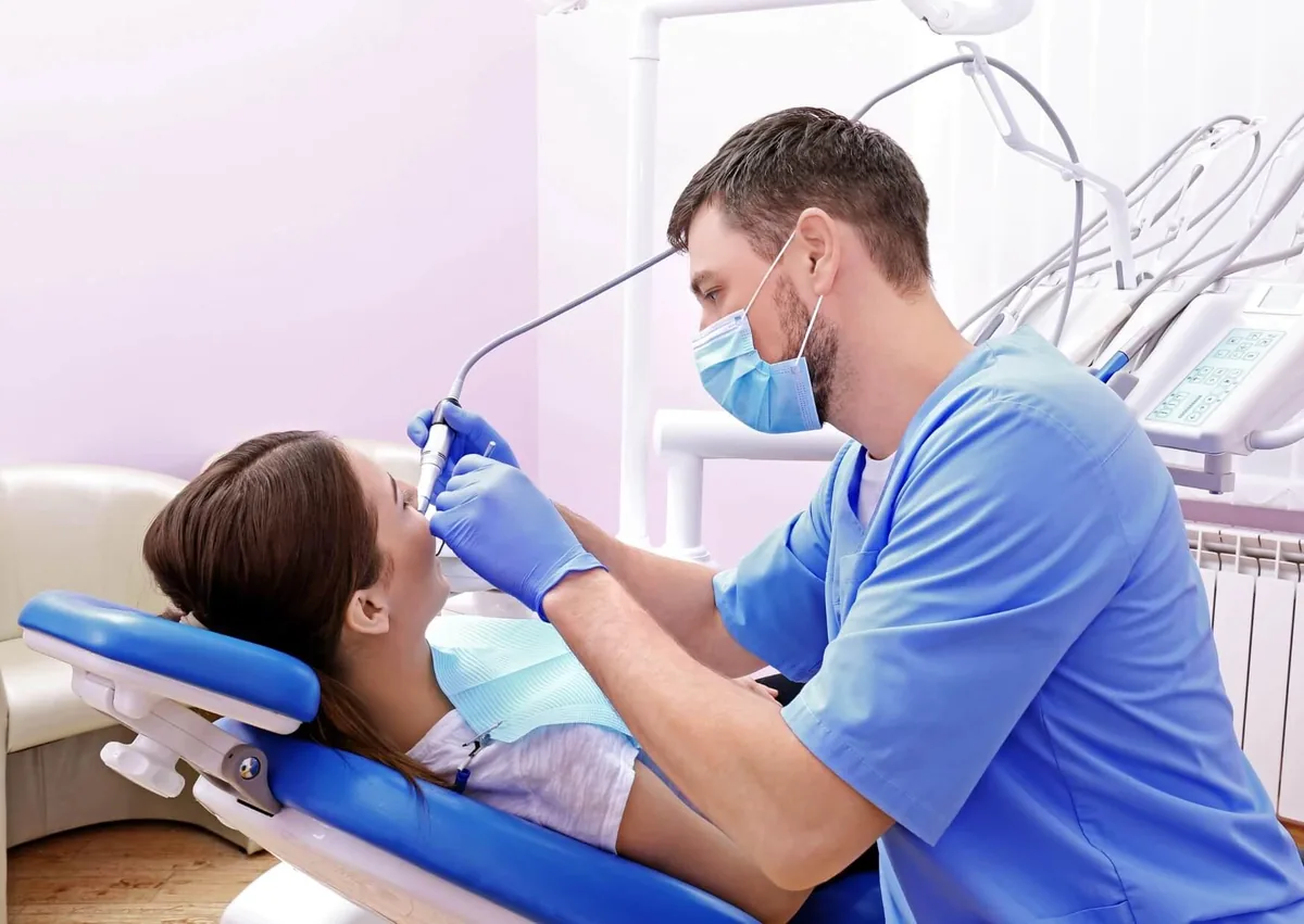 Dentist examining a patient's teeth and gums during a dental checkup to identify signs of gingivitis or periodontitis.